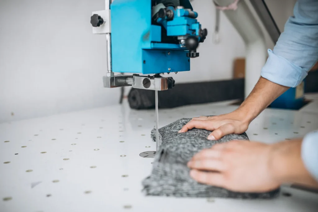 a person cuttiing a textile fabric